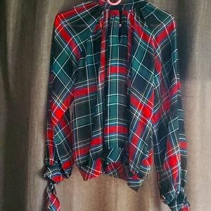 A keyhole detail and semi-sheer fabric, tie details on cuffs.